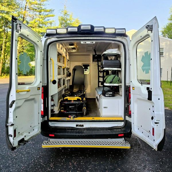 Medex BLS ambulance with rear doors open showing the stretcher